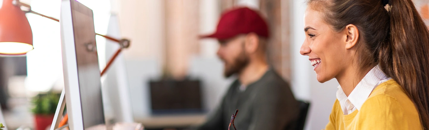 Two people working at computers in modern office.