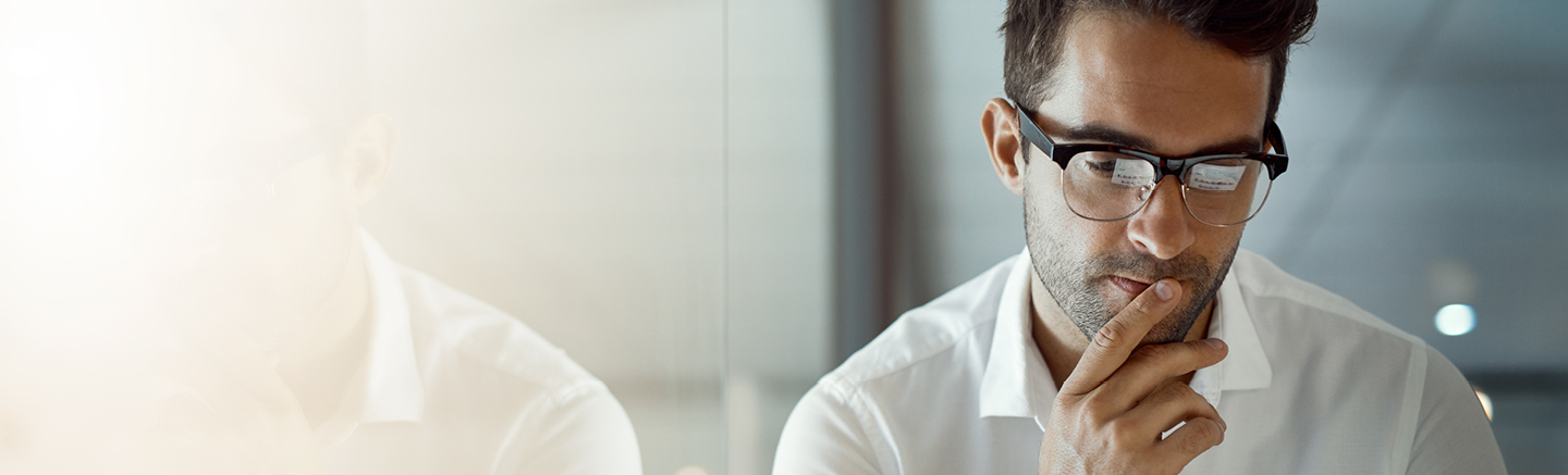 Employer Market Insights - A man with glasses looks at his computer screen. The reflection is on his glasses.