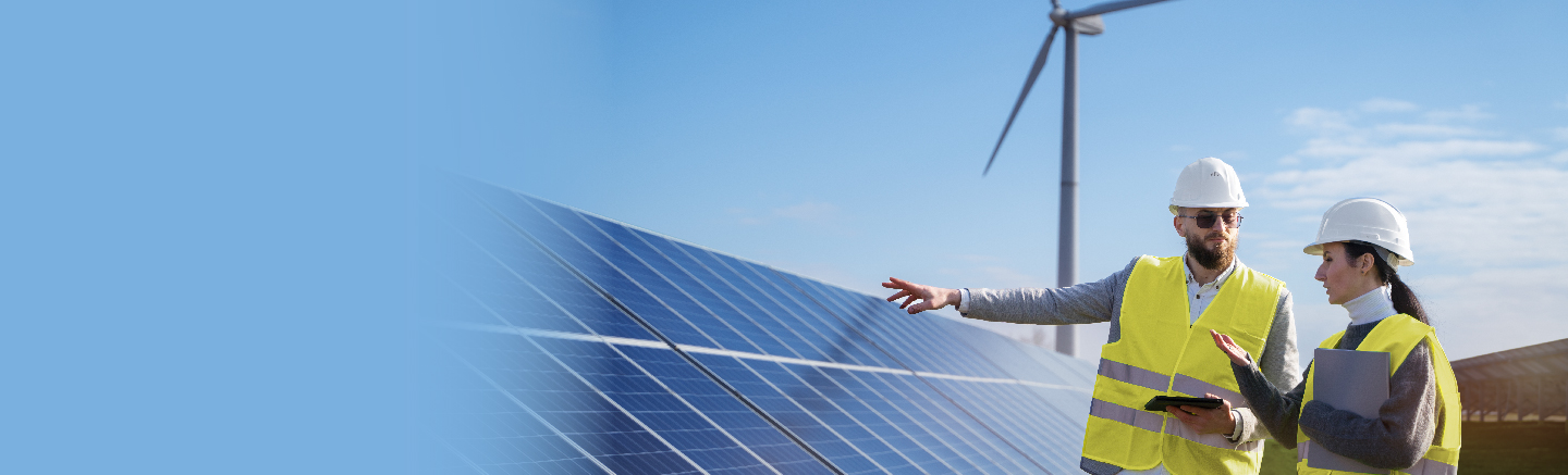Man and woman with safety vests inspecting solar panels